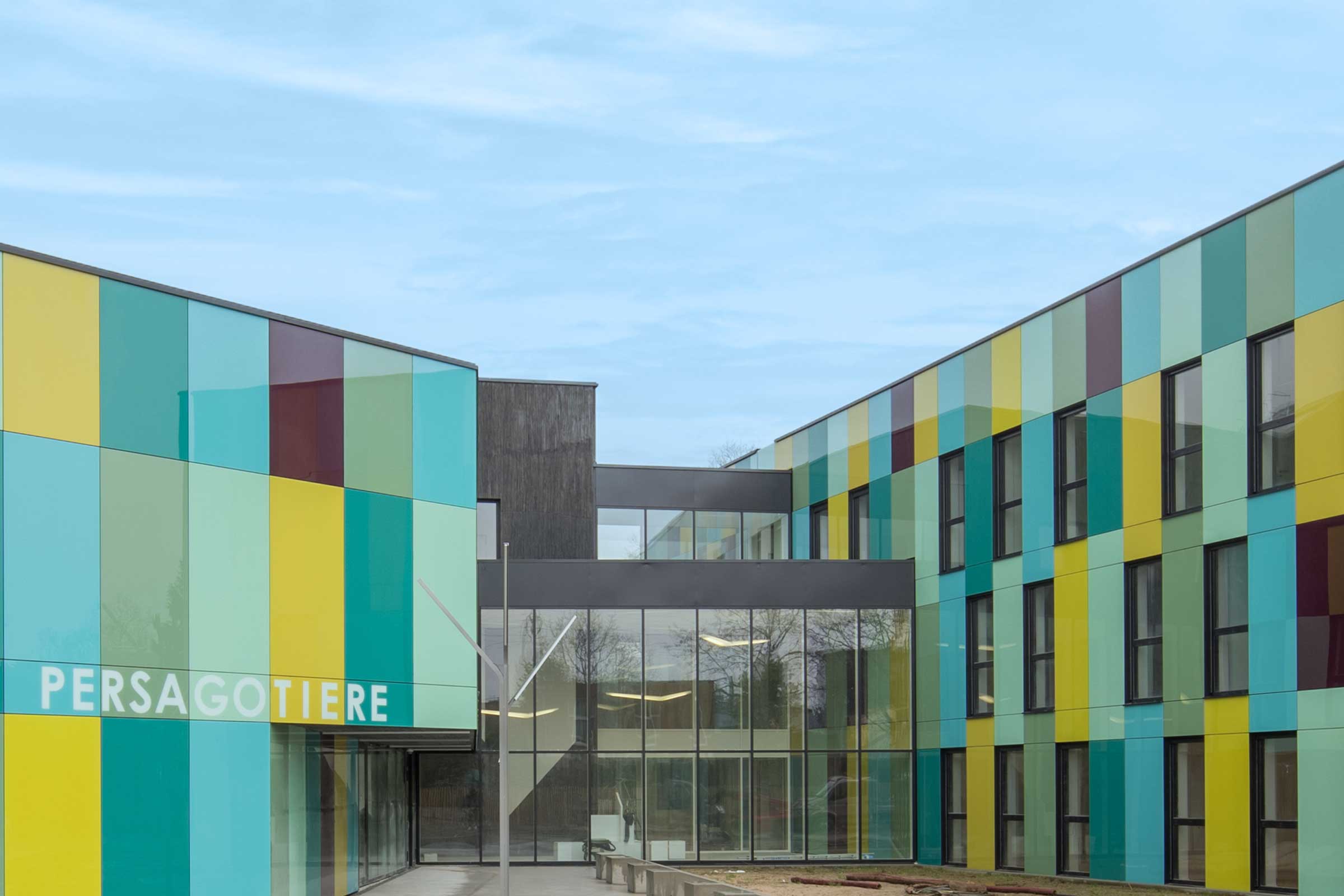 Sistemi di facciate ventilate in vetro con pannelli in blu, verde e giallo. 
