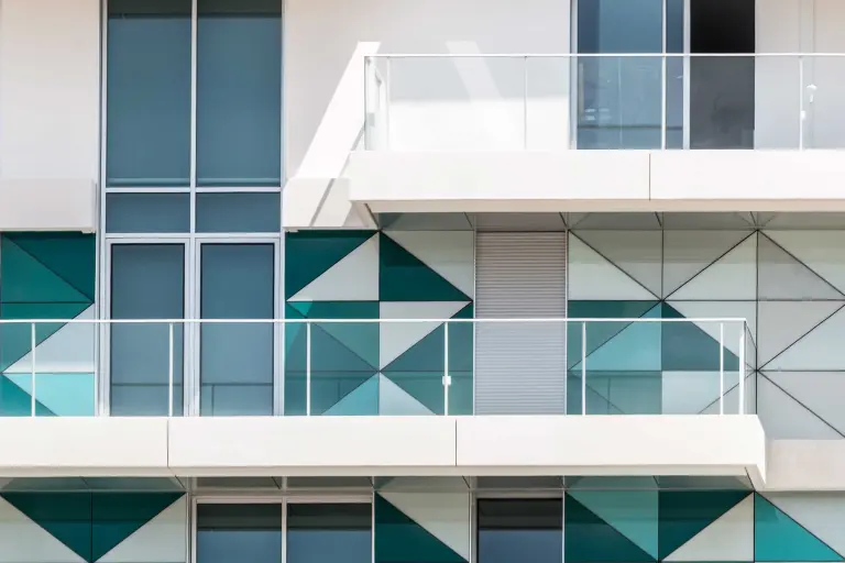 Sistemi facciate ventilate: intonaco esterno e pannelli di vetro nei toni del bianco e del blu.