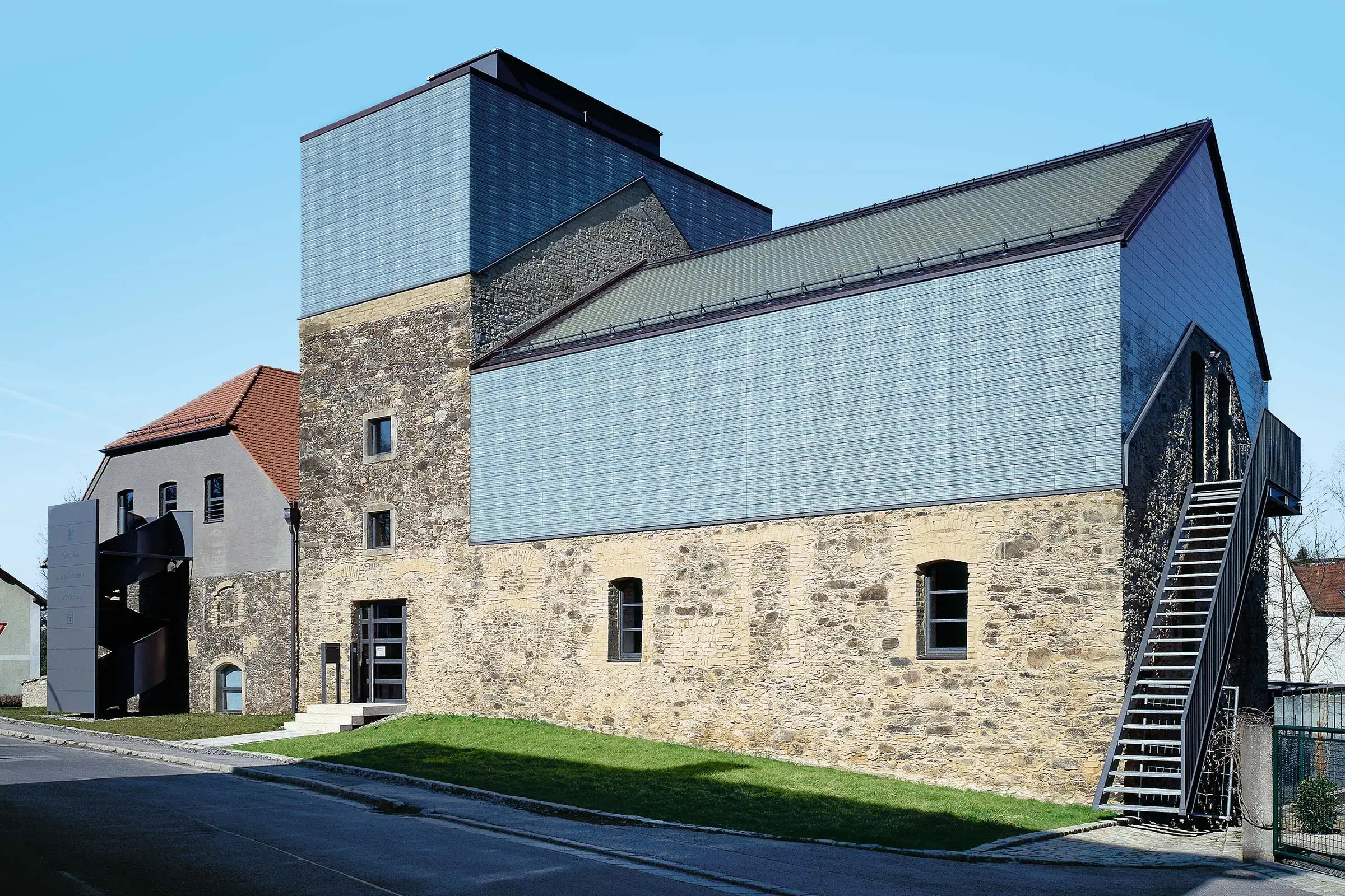 Centro culturale con facciata ventilata mista, pannelli di vetro e pietra: StoVentec G 