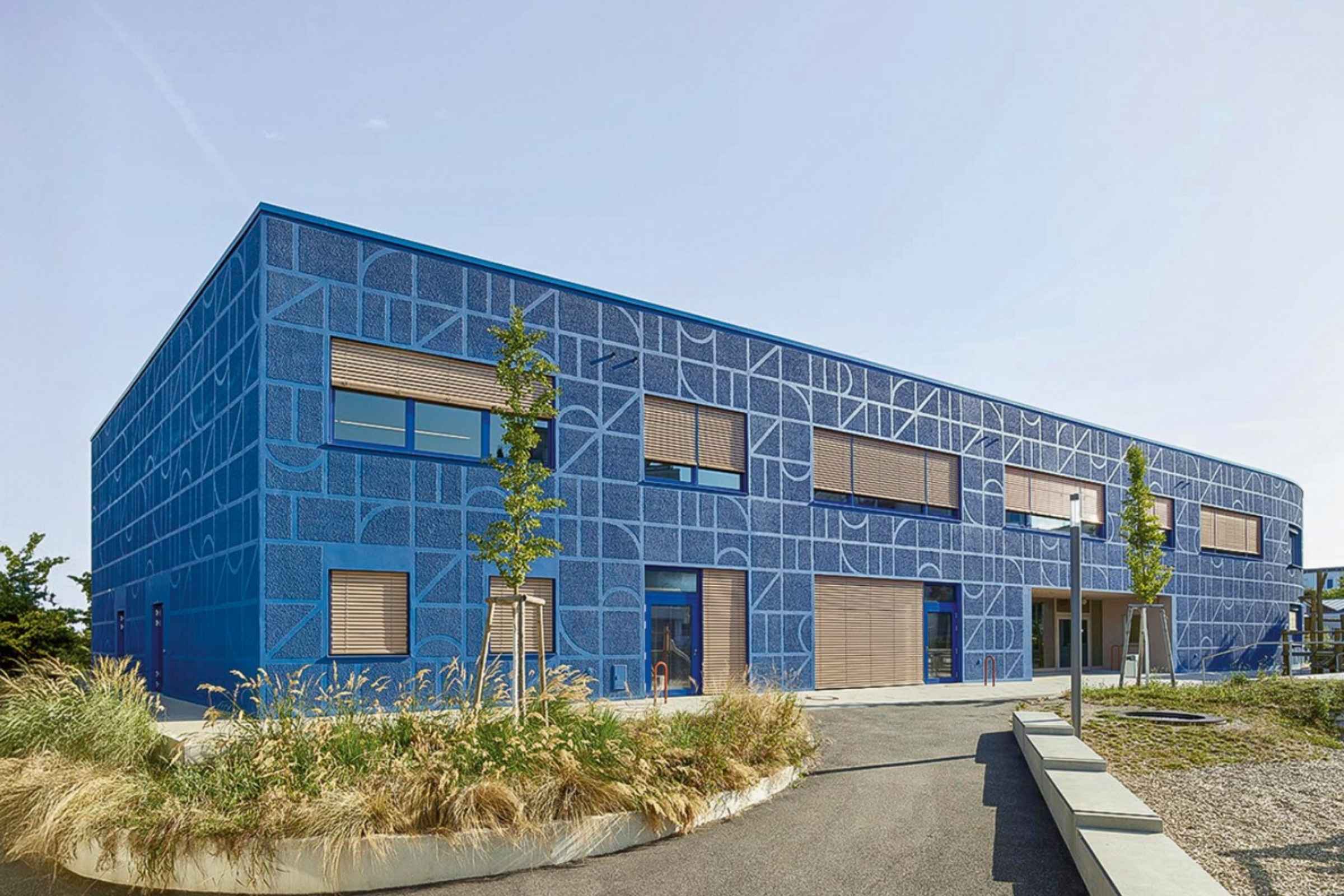 Scuola elementare Montessoriana con finitura intonaco esterno blu in due texture