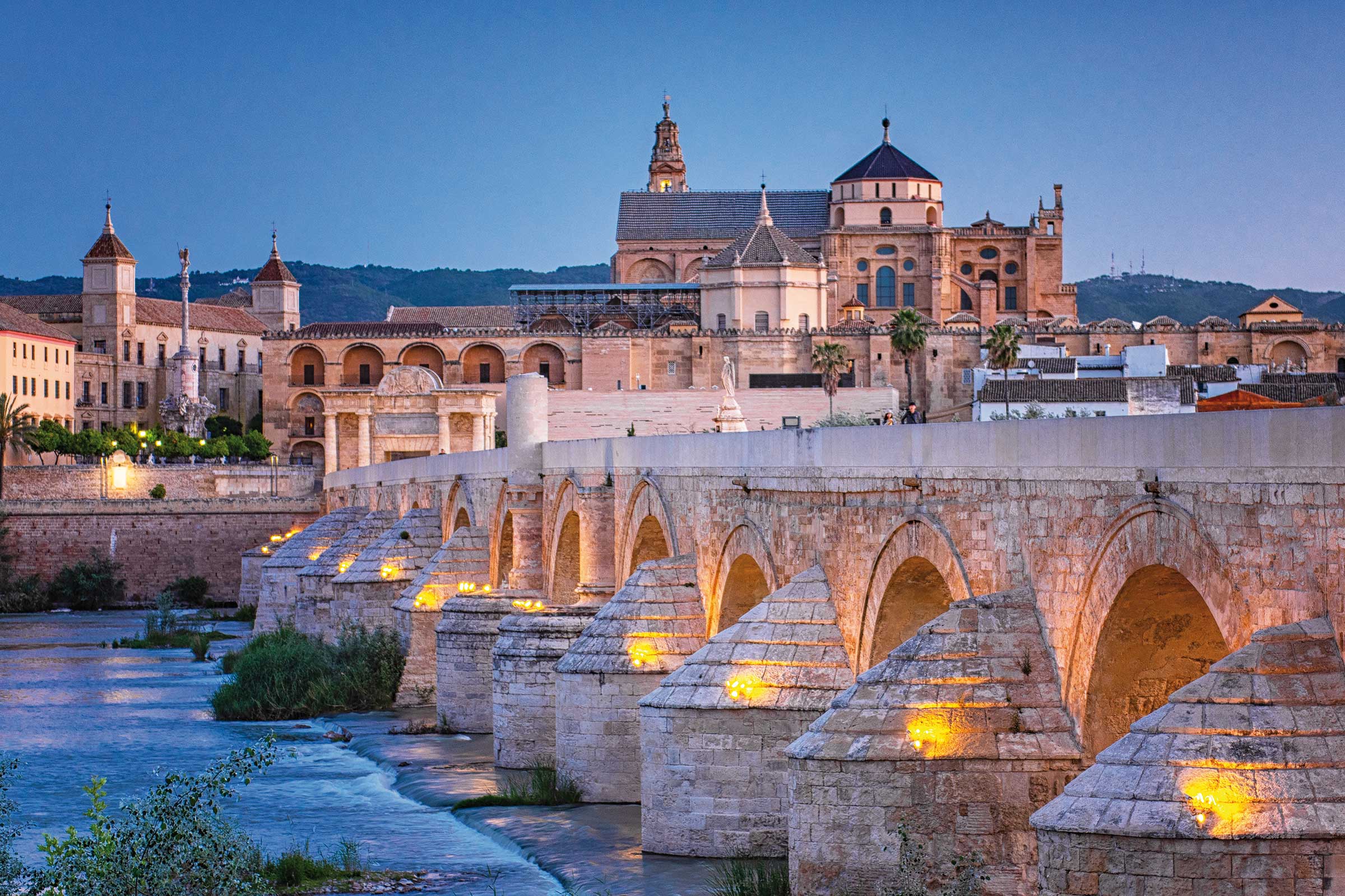 Dämmerungsaufnahme der Puente Romano, romanische Brücke, in Cordoba, Spanien