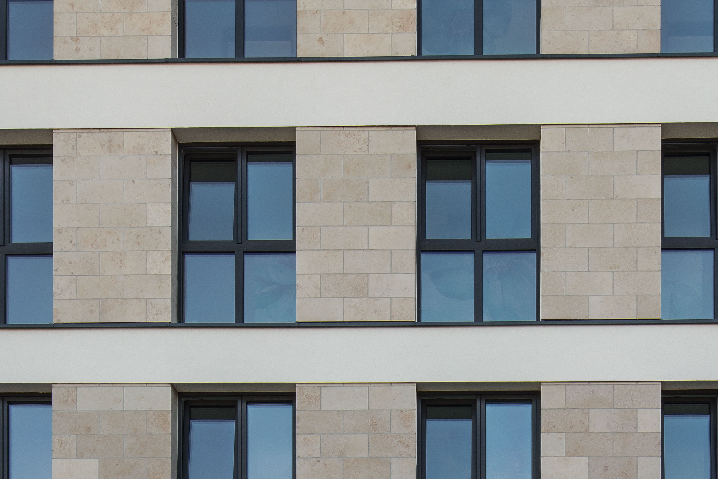 Detailafnahme einer Hausfassade mit Naturstein, Fenster, Fensterbänke von Sto, WDVS-Details
